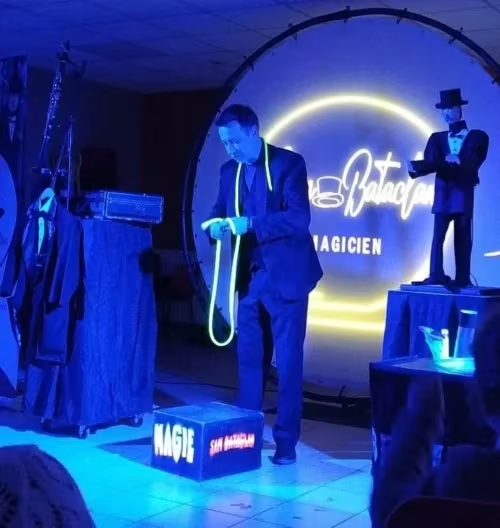 Magie Sam présente un tour de cordes fluorescentes, avec l’automate SAM sur scène